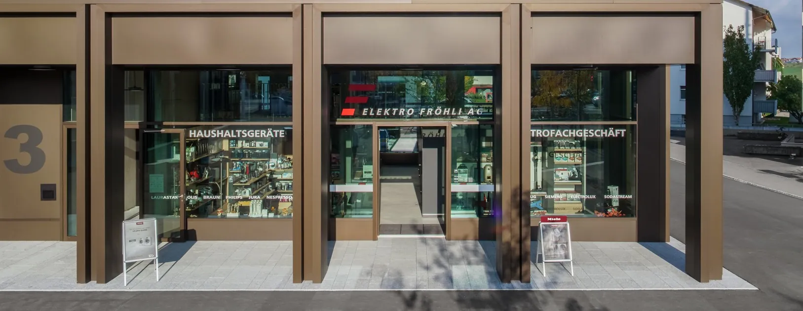 Ladenfront der Elektro Fröhli AG am Mutschellenplatz 3 mit Schaufenstern für Haushaltsgeräte