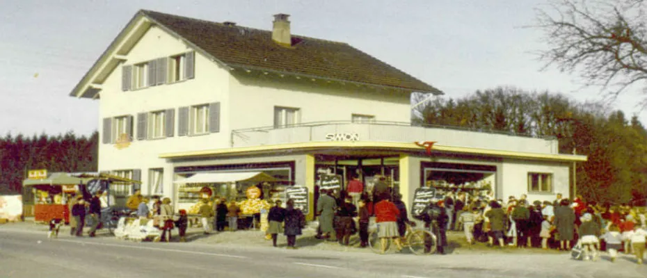 Historische Aufnahme mit vielen Besuchern vor dem Geschäft
