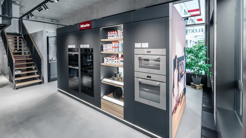 Einbaugeräte-Wand mit Backöfen und Dampfgarern im Miele Competence Center